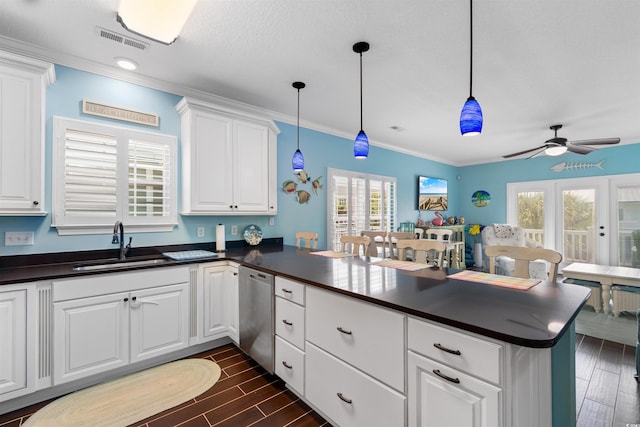 kitchen with sink, kitchen peninsula, stainless steel dishwasher, white cabinetry, and dark hardwood / wood-style floors