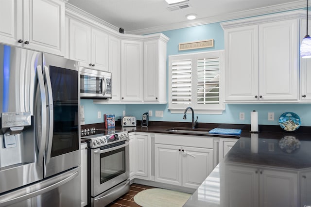 kitchen featuring appliances with stainless steel finishes, white cabinetry, dark wood-type flooring, crown molding, and sink