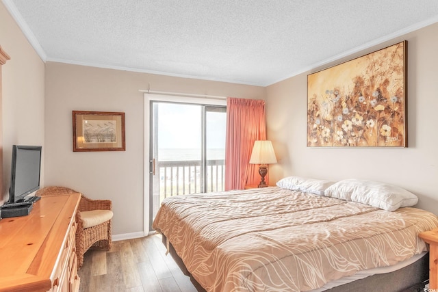 bedroom featuring wood-type flooring, a textured ceiling, access to outside, and crown molding