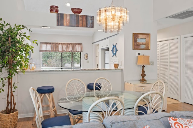 dining area featuring light hardwood / wood-style flooring and a chandelier