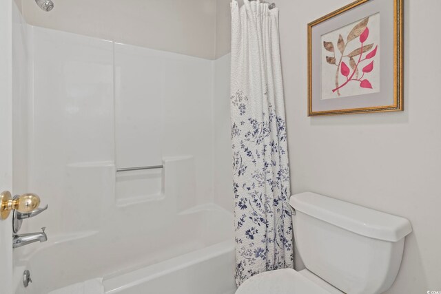 bathroom featuring shower / bath combo and toilet