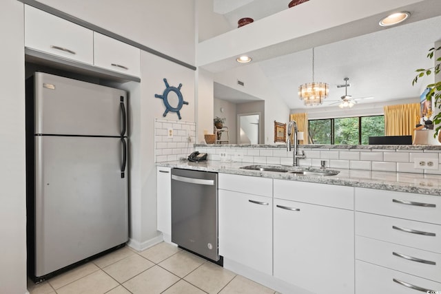 kitchen with backsplash, stainless steel appliances, vaulted ceiling, sink, and white cabinetry