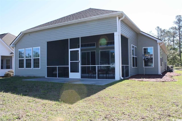 back of property featuring central AC unit, a sunroom, and a yard