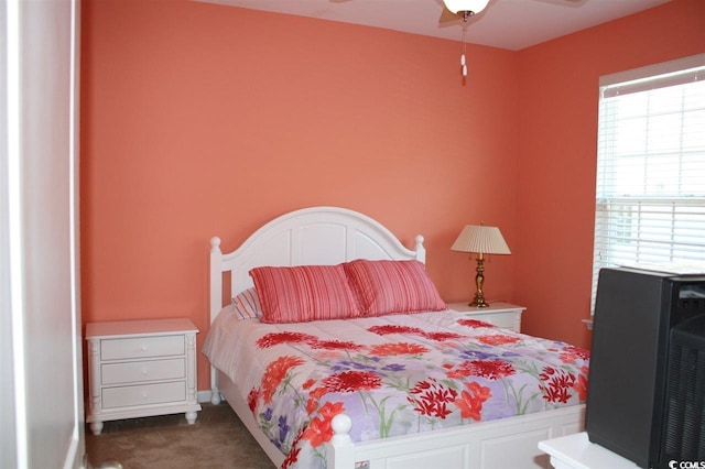 bedroom with dark carpet, multiple windows, and ceiling fan