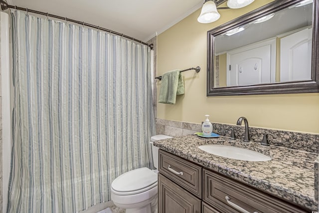 bathroom featuring vanity, ornamental molding, toilet, and tile walls