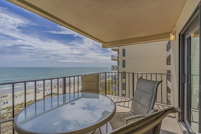 balcony featuring a beach view and a water view