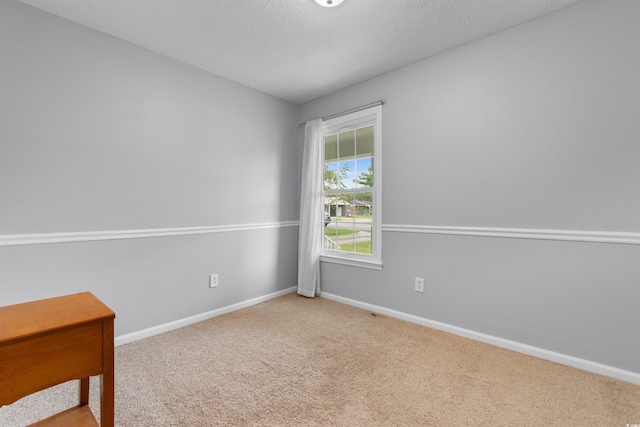 carpeted empty room with a textured ceiling