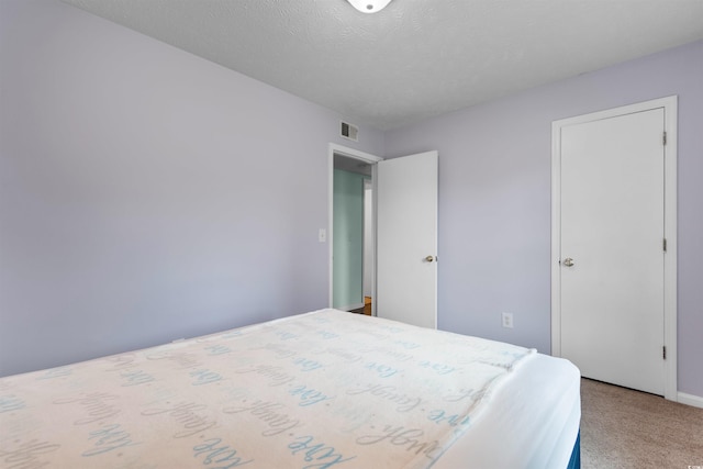 bedroom with carpet floors and a textured ceiling