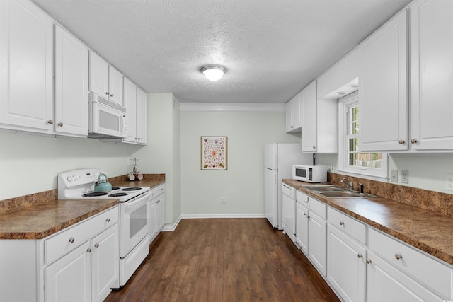 kitchen featuring white cabinets, dark wood-type flooring, and white appliances