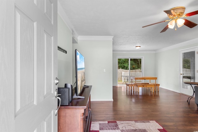 living room featuring a textured ceiling, ornamental molding, dark wood-type flooring, and ceiling fan