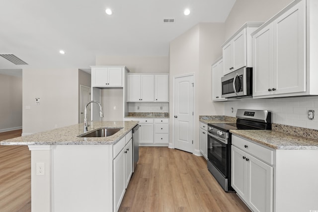 kitchen featuring appliances with stainless steel finishes, light wood-style flooring, a sink, and visible vents