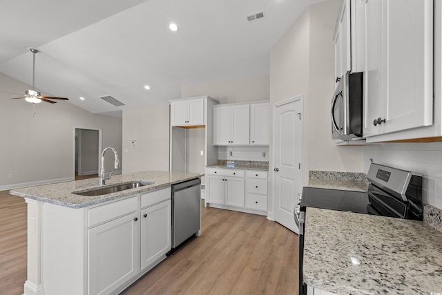 kitchen featuring lofted ceiling, a kitchen island with sink, light wood-style flooring, a sink, and appliances with stainless steel finishes