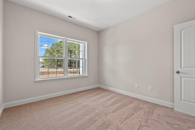 spare room featuring carpet flooring, visible vents, and baseboards