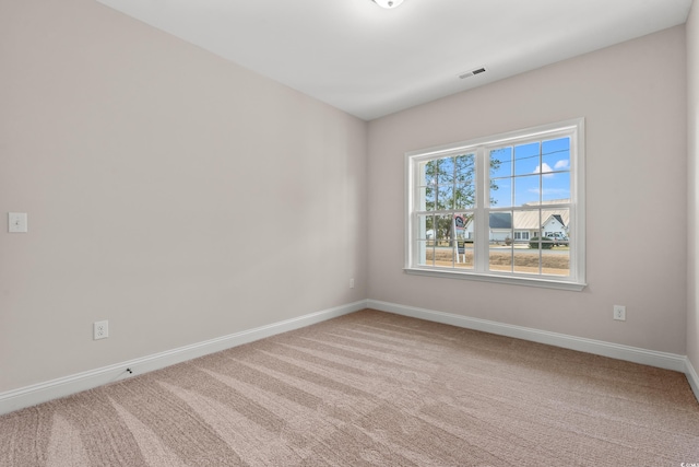 carpeted empty room with visible vents and baseboards