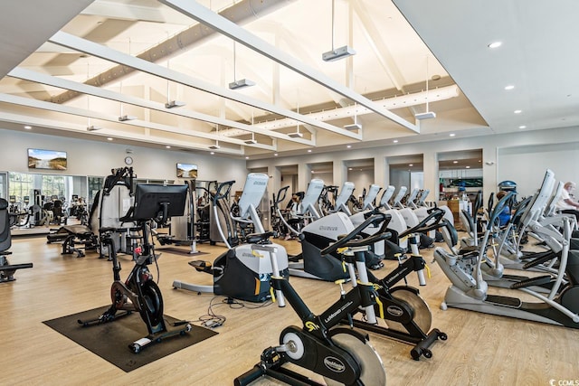 gym featuring hardwood / wood-style flooring and a high ceiling