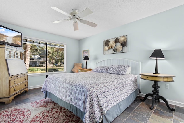 bedroom with ceiling fan and a textured ceiling