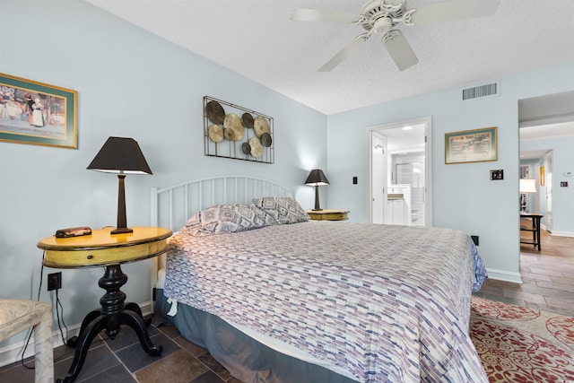 bedroom featuring ceiling fan, ensuite bathroom, and a textured ceiling