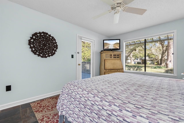 bedroom featuring access to outside, ceiling fan, and a textured ceiling