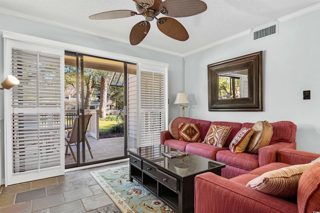 living room with ceiling fan, a healthy amount of sunlight, ornamental molding, and a textured ceiling