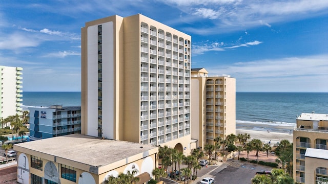 view of building exterior with a water view and a view of the beach