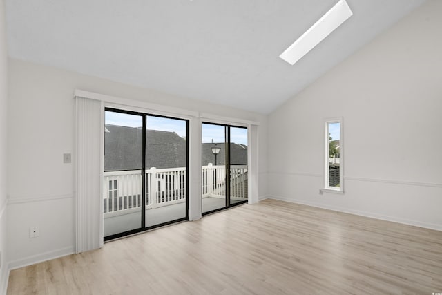 unfurnished room featuring light hardwood / wood-style floors, high vaulted ceiling, and a skylight