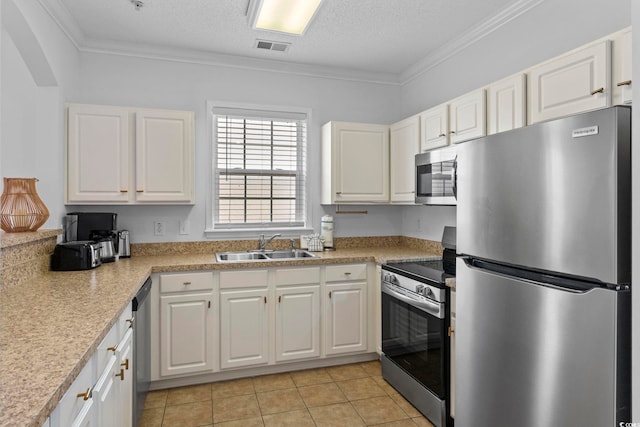 kitchen with crown molding, stainless steel appliances, and white cabinets