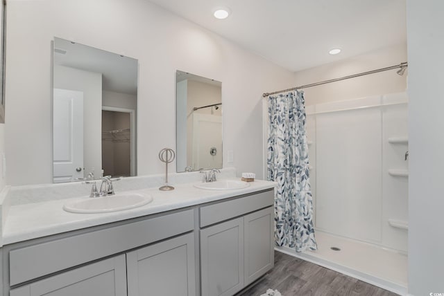 bathroom featuring hardwood / wood-style floors, vanity, and walk in shower