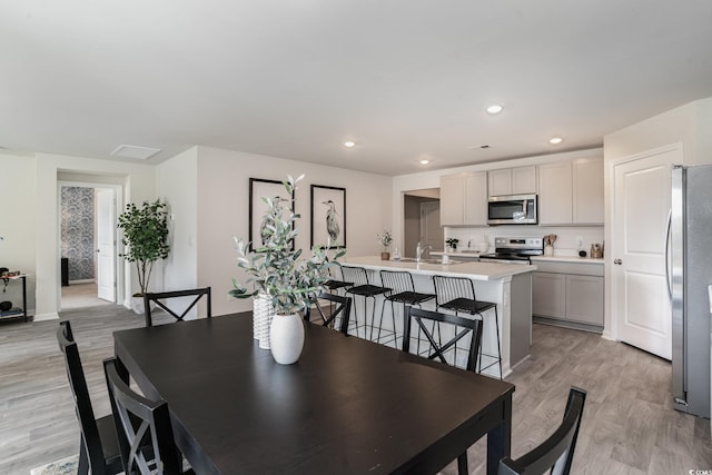 dining room with light hardwood / wood-style flooring and sink