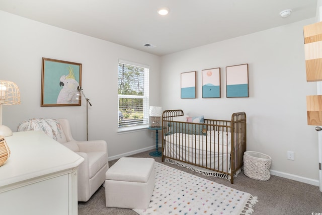 bedroom with a crib and carpet flooring