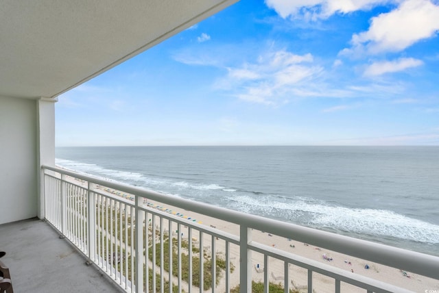 balcony with a water view and a view of the beach