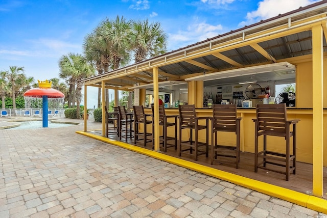 surrounding community featuring a community pool, an outdoor bar, and pool water feature