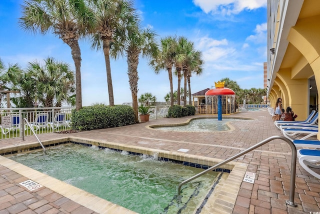 view of swimming pool featuring a hot tub