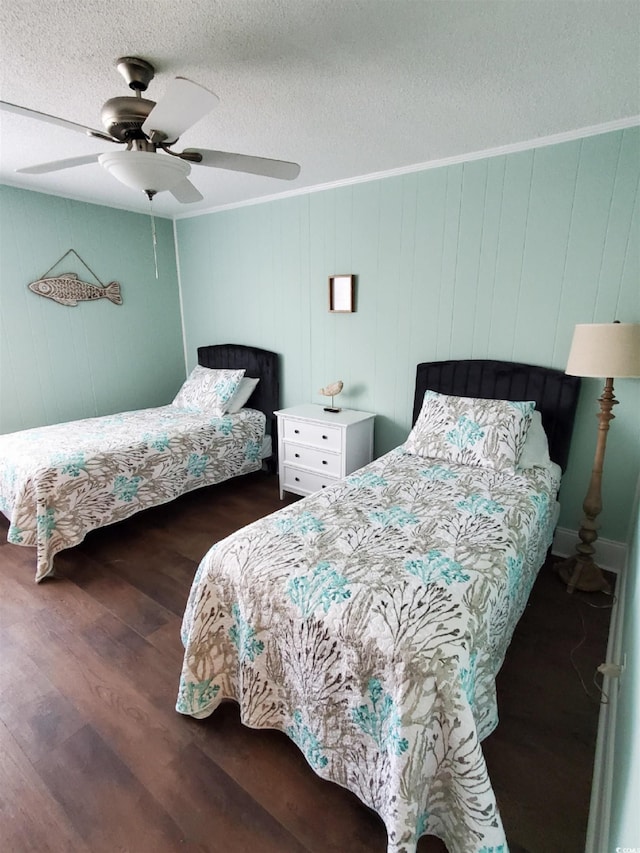 bedroom with a textured ceiling, crown molding, ceiling fan, wooden walls, and dark hardwood / wood-style floors