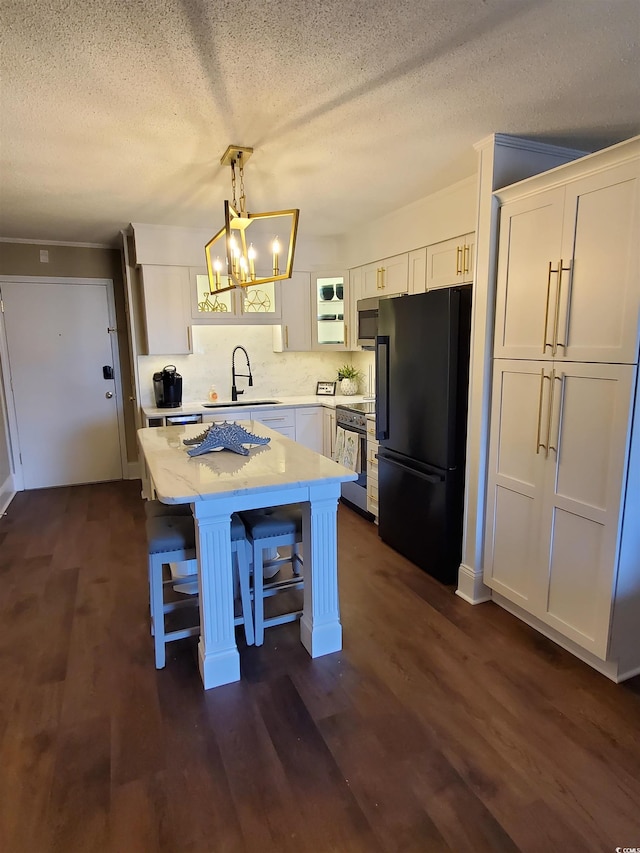 kitchen featuring dark hardwood / wood-style floors, sink, white cabinets, a kitchen island, and stainless steel appliances