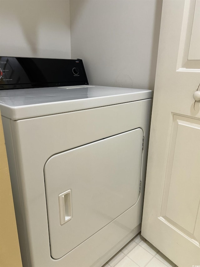 clothes washing area featuring light tile patterned floors and washer / dryer