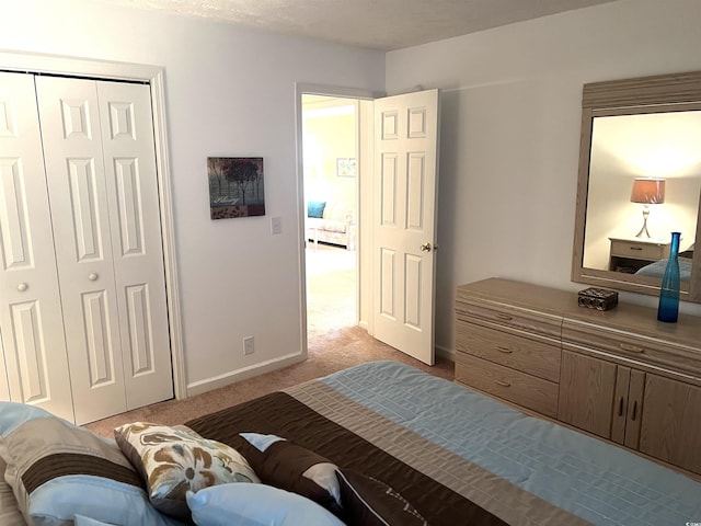 bedroom featuring a textured ceiling, light carpet, and a closet