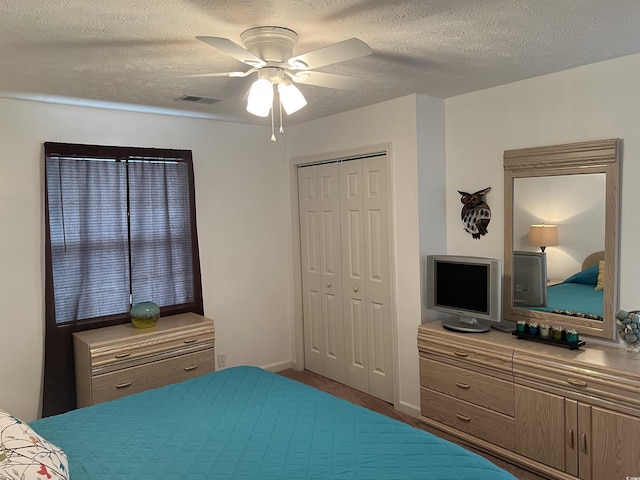 bedroom with ceiling fan, a textured ceiling, and a closet