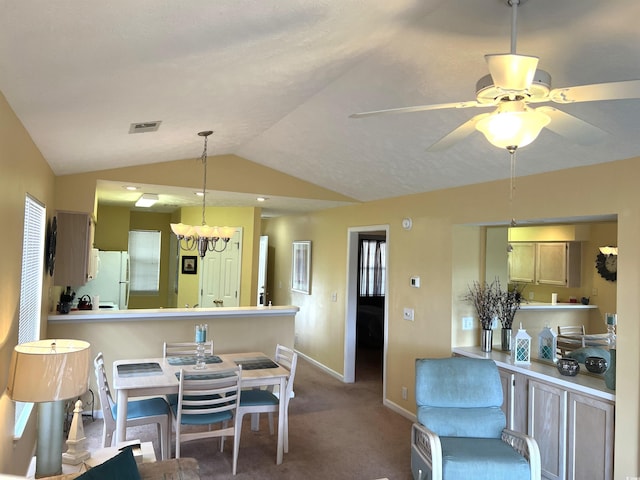 dining room featuring carpet, ceiling fan with notable chandelier, and vaulted ceiling