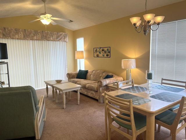 carpeted dining room with ceiling fan with notable chandelier and lofted ceiling