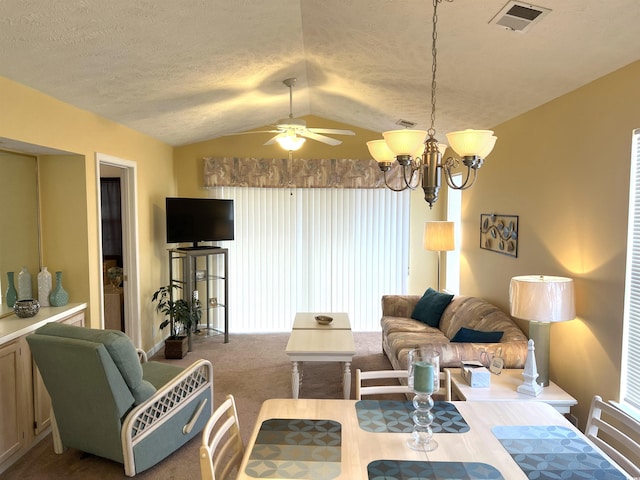 carpeted living room featuring ceiling fan with notable chandelier and vaulted ceiling