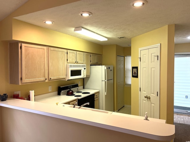 kitchen with kitchen peninsula, light brown cabinetry, white appliances, a textured ceiling, and sink