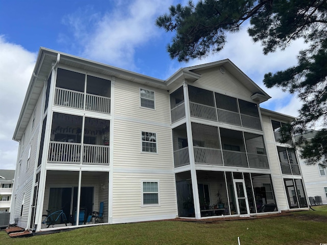 rear view of property featuring a yard and central AC unit