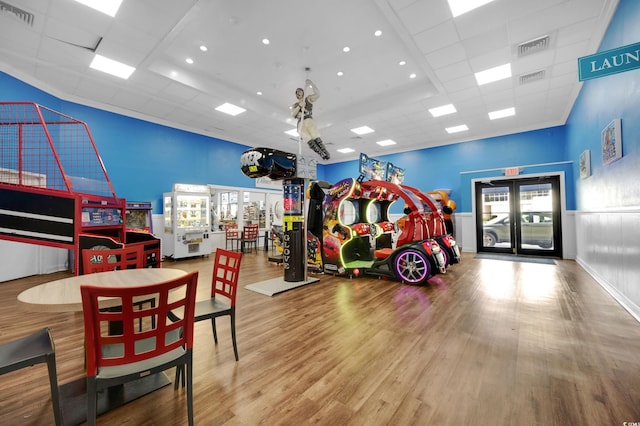 rec room featuring hardwood / wood-style flooring, a drop ceiling, and a healthy amount of sunlight