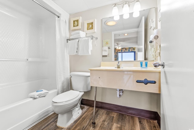 full bathroom featuring ceiling fan, vanity, hardwood / wood-style floors, toilet, and shower / tub combo with curtain