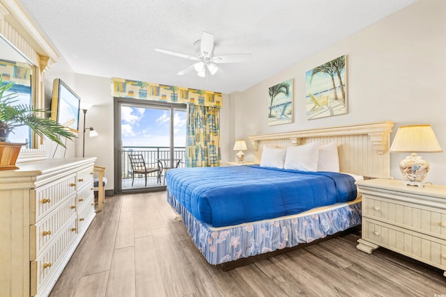 bedroom featuring a textured ceiling, wood-type flooring, access to outside, and ceiling fan