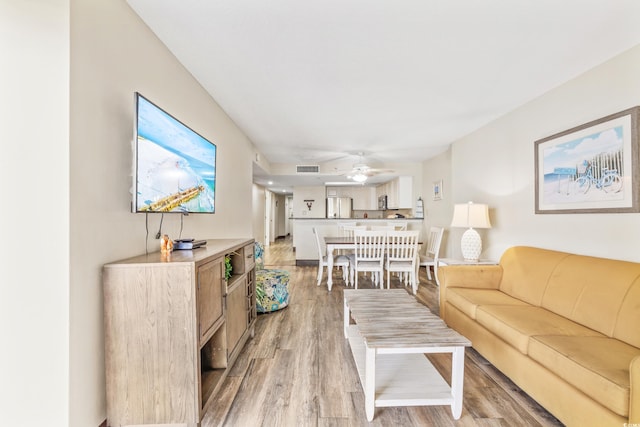 living room featuring light hardwood / wood-style flooring and ceiling fan