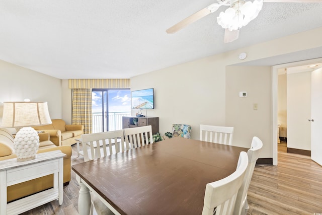 dining space featuring ceiling fan, a textured ceiling, and light wood-type flooring