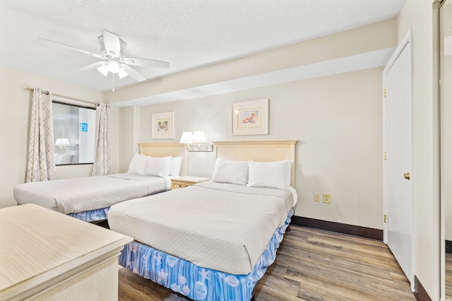 bedroom featuring ceiling fan, hardwood / wood-style flooring, and a textured ceiling