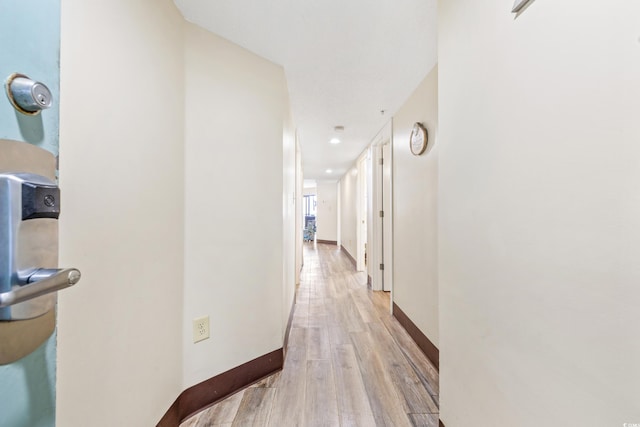 hallway with light hardwood / wood-style floors