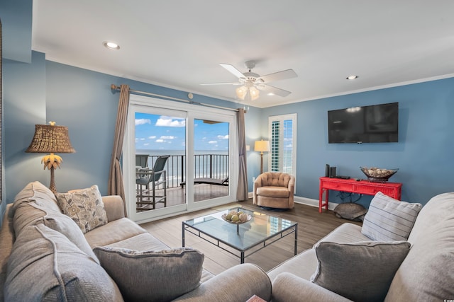 living room featuring ceiling fan, ornamental molding, and wood-type flooring